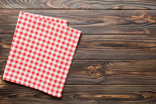 top view with red empty kitchen napkin isolated on table background. Folded cloth for mockup with copy space, Flat lay. Minimal style.