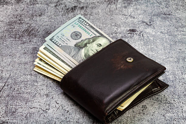 istock 100 american dollar banknotes sticking out of a leather wallet. 1500560585