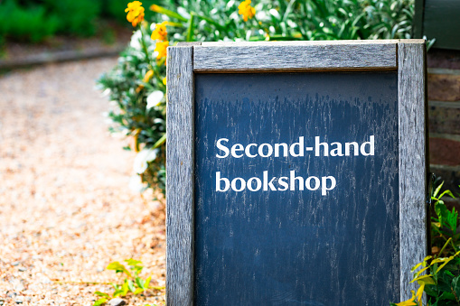 An outdoors sign advertising a shop selling used books.