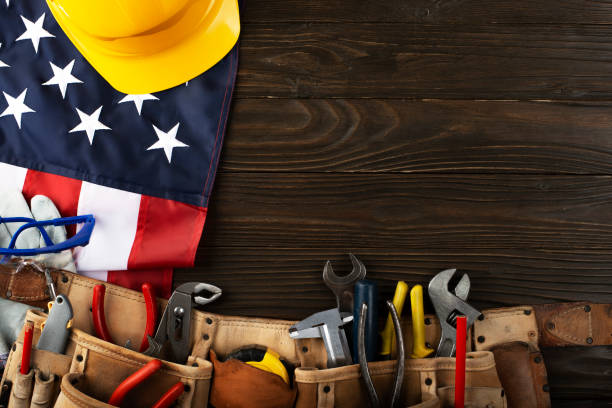 istock Tools hardhat toolbelt and us flag on wooden background labor day banner mockup 1500561487