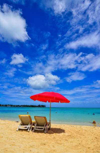 Red umbrella with relaxing chairs on Mauritius Island. Mauritius is one of the best destinations,  known for its beaches, lagoons and reefs.