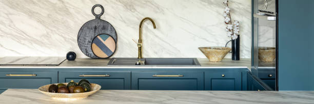 istock Luxury modern and vintage turquoise and white kitchen. Marble kitchen island with white owal chandelier . Gold tap on marble table top. Template. 1500566181
