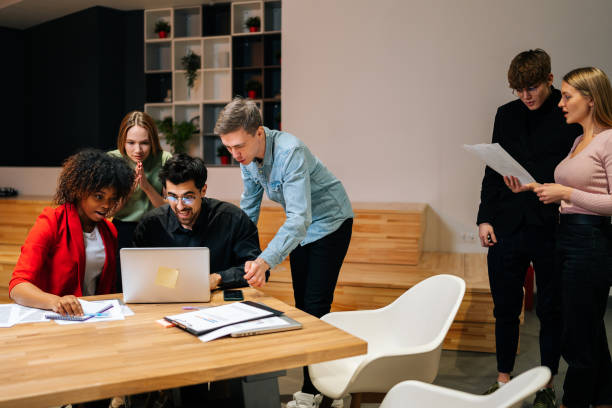 istock Cheerful diverse multiethnic creative millennial team excited by online result or growth, good news, business success looking at laptop laughing together 1500567565