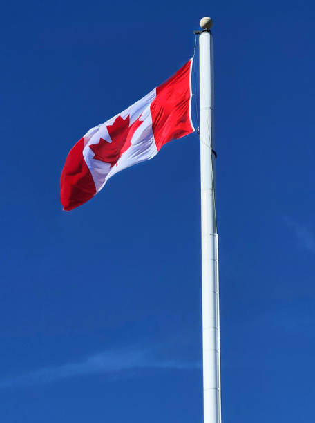 istock Canadian flag against blue sky 1500571031