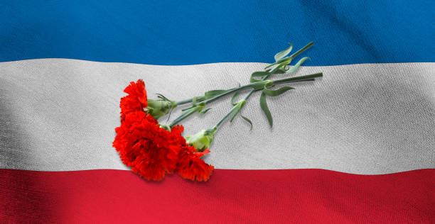 istock three red carnations lying on the flag of Serbia 1500571836