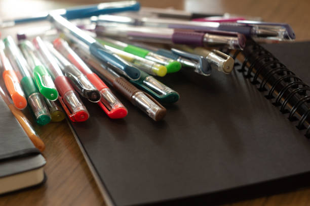 istock a set of colored pens scattered on a black notebook on the table 1500571941