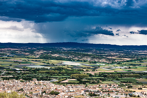 panoramic view with stormy sky over the Emporda region (Spain) and over the village of Torroella de Montgrí in the province of Girona.