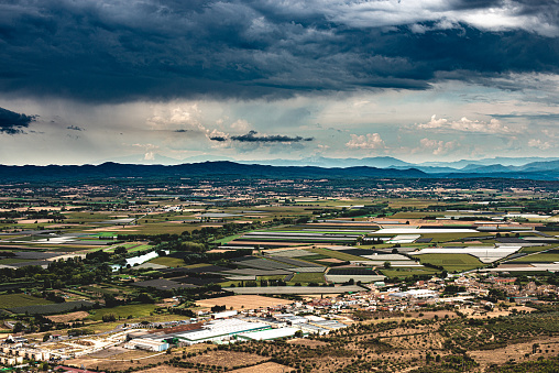 panoramic view with stormy sky over the Emporda region (Spain) and over the village of Torroella de Montgrí in the province of Girona.