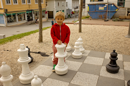 Child, enjoying the local games of Odda, chess, iron horse, iron ant, tourist visiting Odda summertime