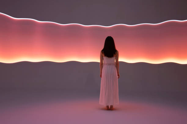Young woman standing in front of orange light trails.
