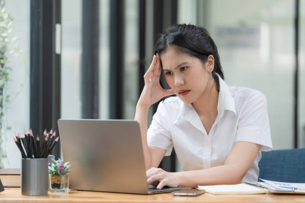 istock An Asian businesswoman is serious at work causing headaches and stressed out with documents with a laptop at the office. 1500583942
