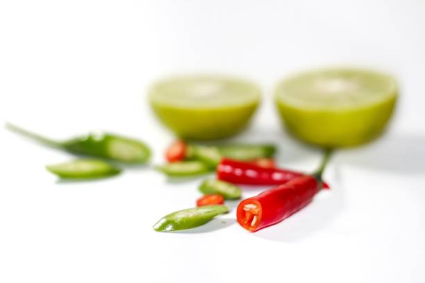 Red chili peppers lined on a wooden cutting board and blue cloth