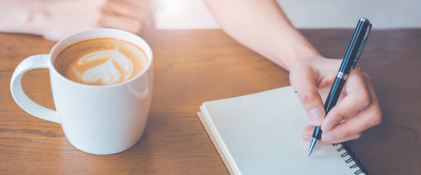 istock Woman hand is writing on notepad with a pen in the office. 1500594265