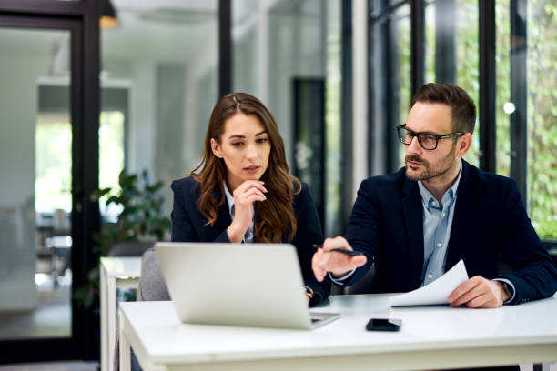istock Serious businesspeople working together on a laptop at the office table. 1500594573