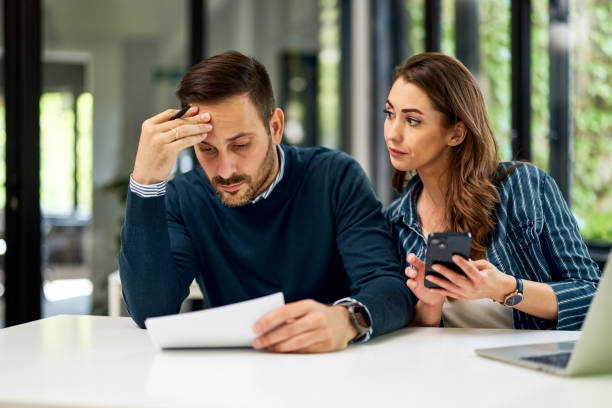 istock A serious male boss solves the financial problem with his female employee. 1500597794
