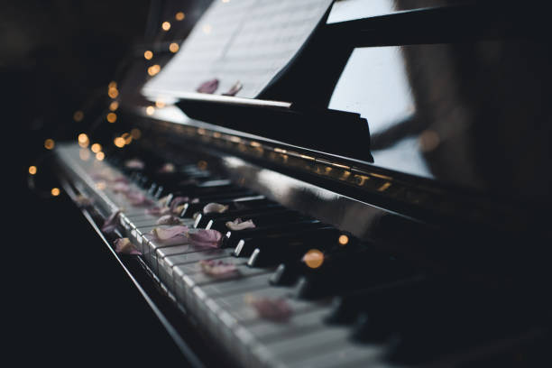 istock Piano keys with rose petals in dark closeup 1500600066