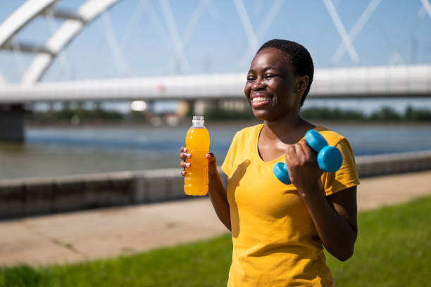 istock Woman holding energy drink  and weights 1500602649