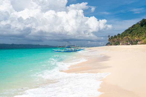 istock White Sand (Puka Shell) Beach on Boracay Island - Stormy Clouds and Palm Trees. 1500602750
