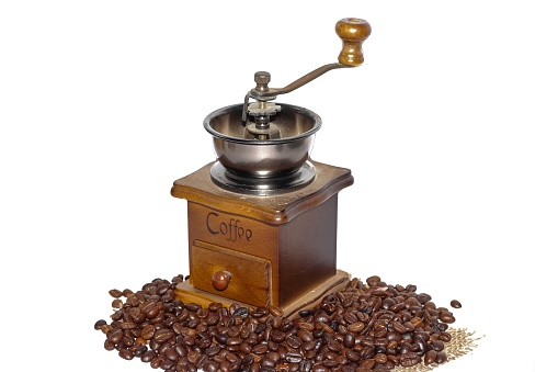 vintage coffee grinder with manufacture roasted Indonesian Arabica coffee beans on rustic wooden background