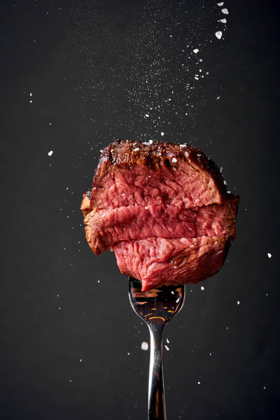 istock Fillet Mignon is sprinkled with salt and spices on a fork. Medium roasting 1500607113