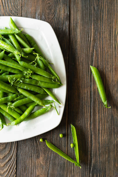 istock Fresh green peas on a wooden background 1500607398