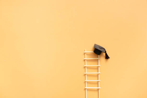 istock Graduation hat with ladder on an orange background with copy space 1500608164