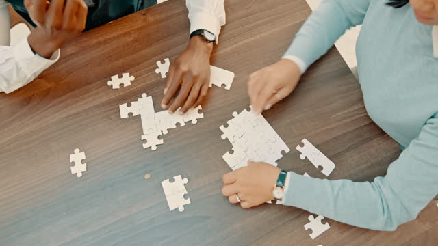 Top view, hands and busines people with puzzle for strategy, planning and company growth vision. Above teamwork, collaboration and jigsaw game piece for solution, problem solving and innovation
