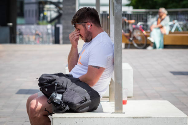 Heatwave in London, a man exhausted by heat at the Granary Square in Kings Cross London, UK - 21 June, 2022 - Heatwave in London, a man exhausted by heat at the Granary Square in Kings Cross heat haze stock pictures, royalty-free photos & images