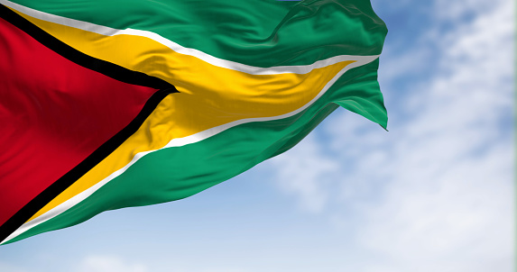 Close-up view of the Guyana national flag waving in the wind on a clear day. South American country 3d illustration render. Fluttering fabric