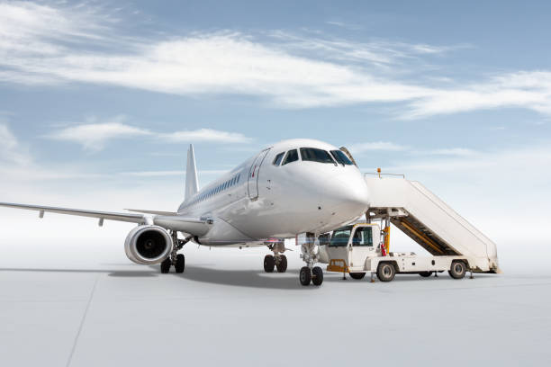 istock White passenger airplane with a boarding steps isolated on bright background with sky 1500614139
