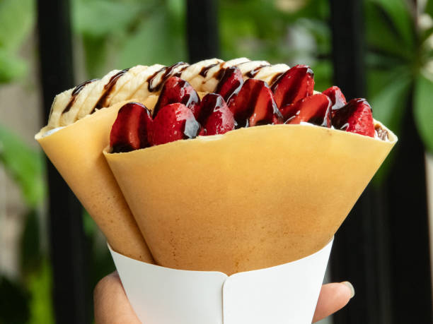Crispy crepe filled with luscious strawberry whipped cream is a delightful treat that combines the satisfying crunch of the crepe with the light and creamy sweetness of the strawberry filling.close up
