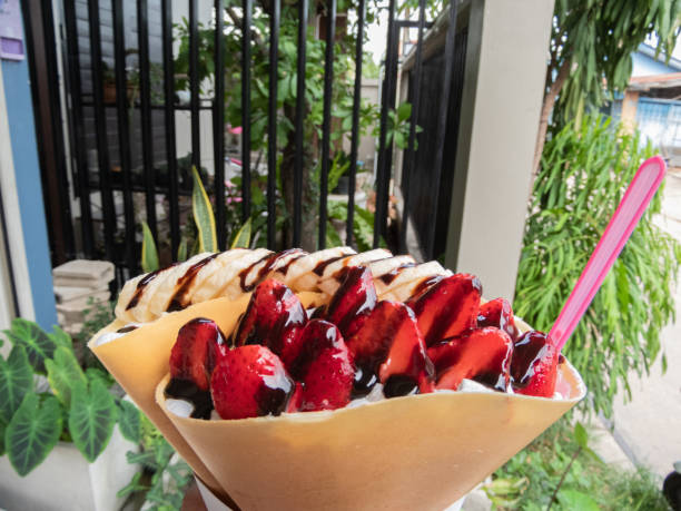 Crispy crepe filled with luscious strawberry whipped cream is a delightful treat that combines the satisfying crunch of the crepe with the light and creamy sweetness of the strawberry filling.close up