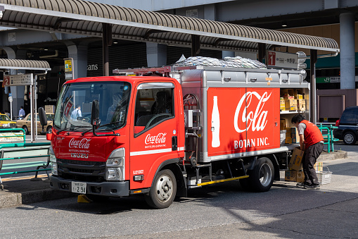 Tokyo, Japan - May 30 , 2023 : Deliveryman and Coca-Cola delivery truck in Tokyo, Japan.