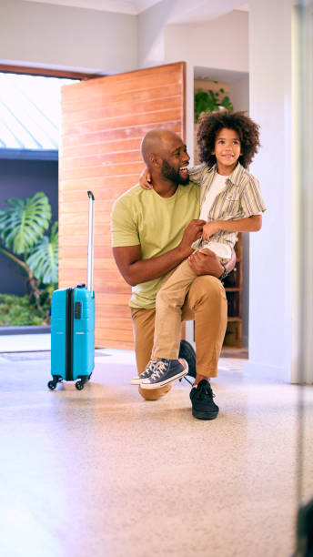 istock Son Greeting Father Returning Home With Luggage From Trip Away 1500619379