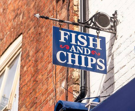 A simple sign for a fish and chips takeaway on the street.