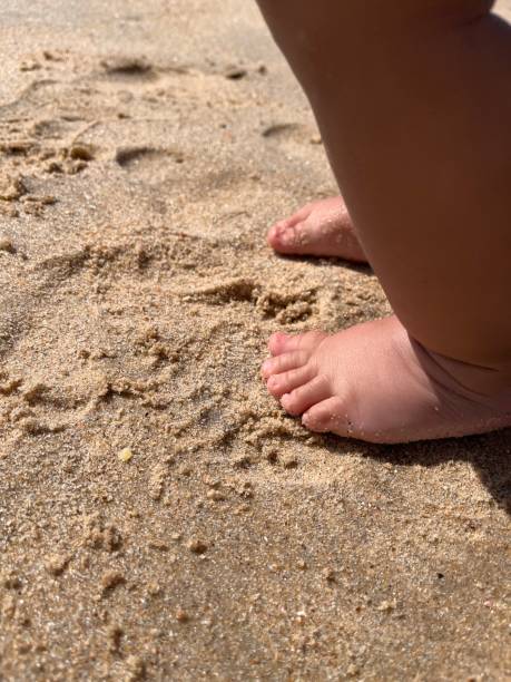 toddler baby feet on the sand beach. Vacation and travel with small children concept.