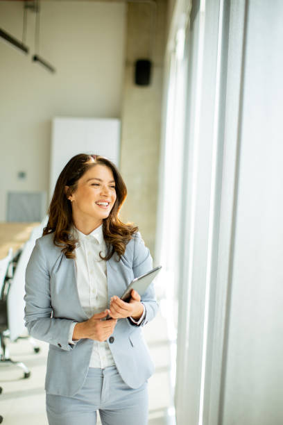 istock Young woman working on digital tablet by the office window 1500623432