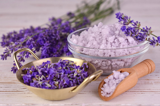 Lavender bath salt with fresh lavender flowers on a white background.
