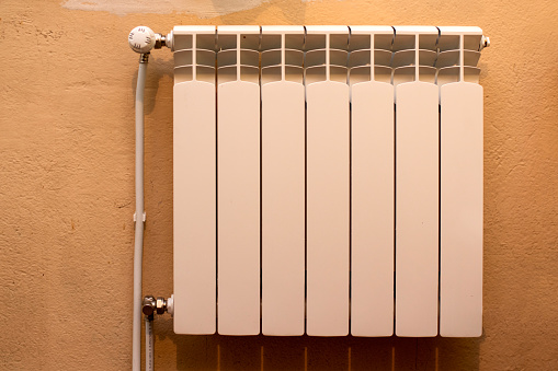 White radiator hanging on the wall in an old house.