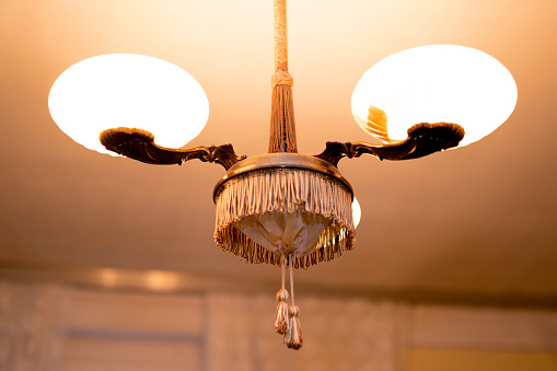 Vintage chandelier in the rustic room with fringes, old fashioned.