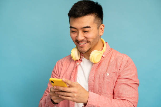 istock Asian man uses mobile phone and wireless headset. 1500627395