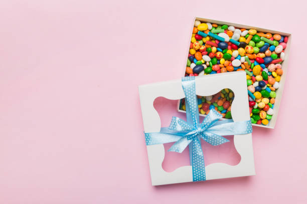 istock Box with sweet chocolate candies on color background, Various candy sweets. Valentines day gift box. Top view flat lay with copy space 1500627640