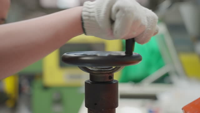 woman scientist's hand opens the valve of  manufacturing production machine