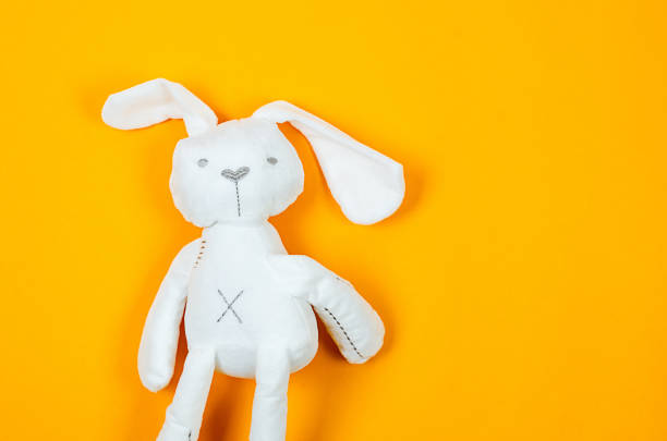 istock cute baby toy fluffy plush bunny on yellow background 1500634090