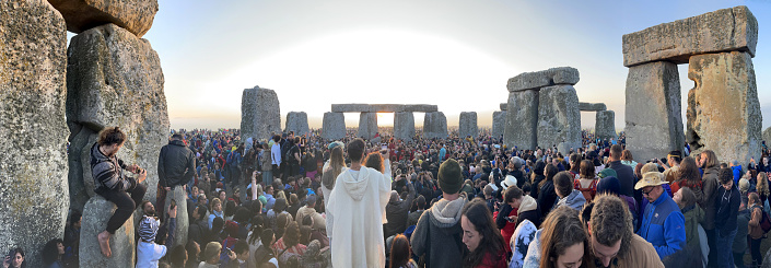 Panorama of crowds at the ancient Stonehenge stone circle as Summer Solstice dawns