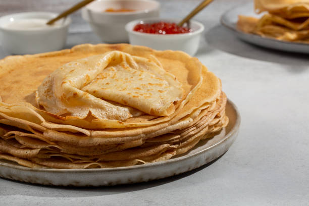 istock Crepes on gray table . Thin pancakes served with jam and sour cream. 1500645529
