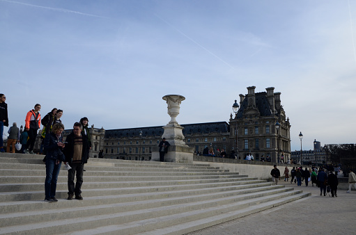 Paris, France - March 16, 2023: People at the stairs between Louvre museum and Tuileries garden in Paris, France.