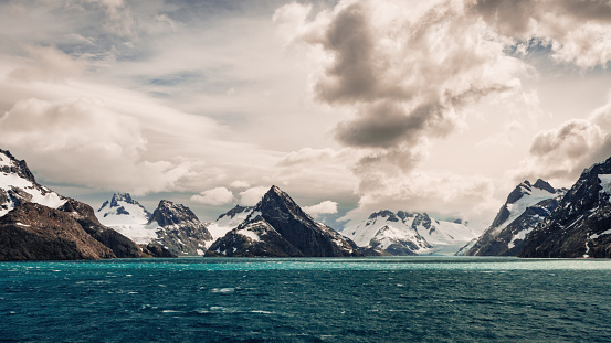 Blue ice occurs when snow falls on a glacier, is compressed, and becomes part of the glacier. During compression, air bubbles are squeezed out so ice crystals enlarge. This enlargement is responsible for the ice's blue color.