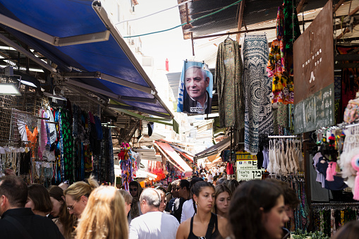 Tel Aviv, Israel - June 12, 2023: A picture of Israel's prime minister, Benjamin Netanyahu, hangs above a busy alley in the Carmel Market.