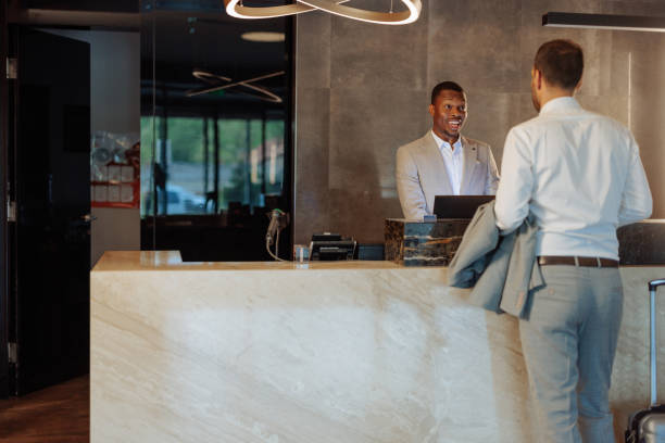 Suited African-American hotel receptionist excited to see a new guest arriving